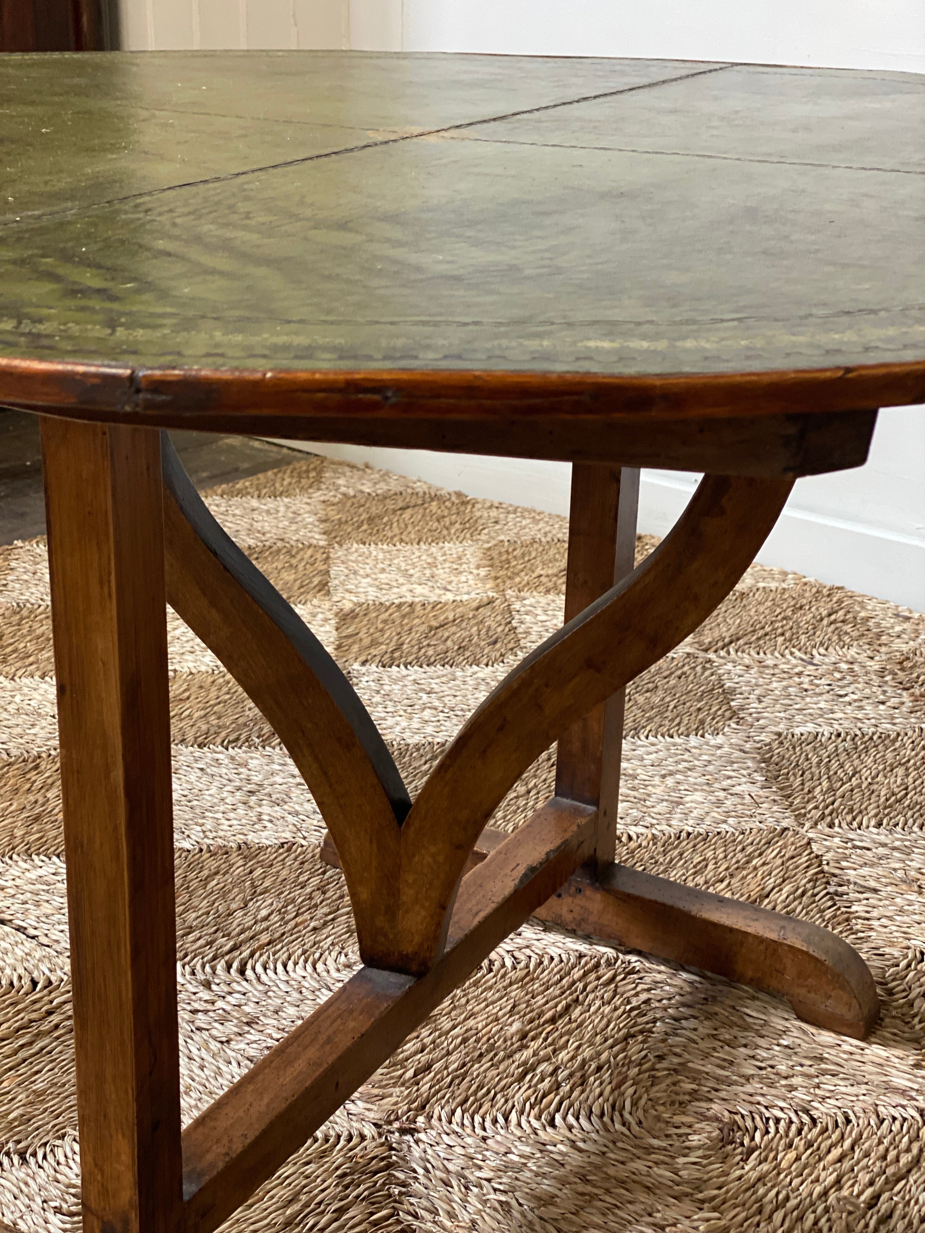 Early C20th French vendange wine table with green leather top.