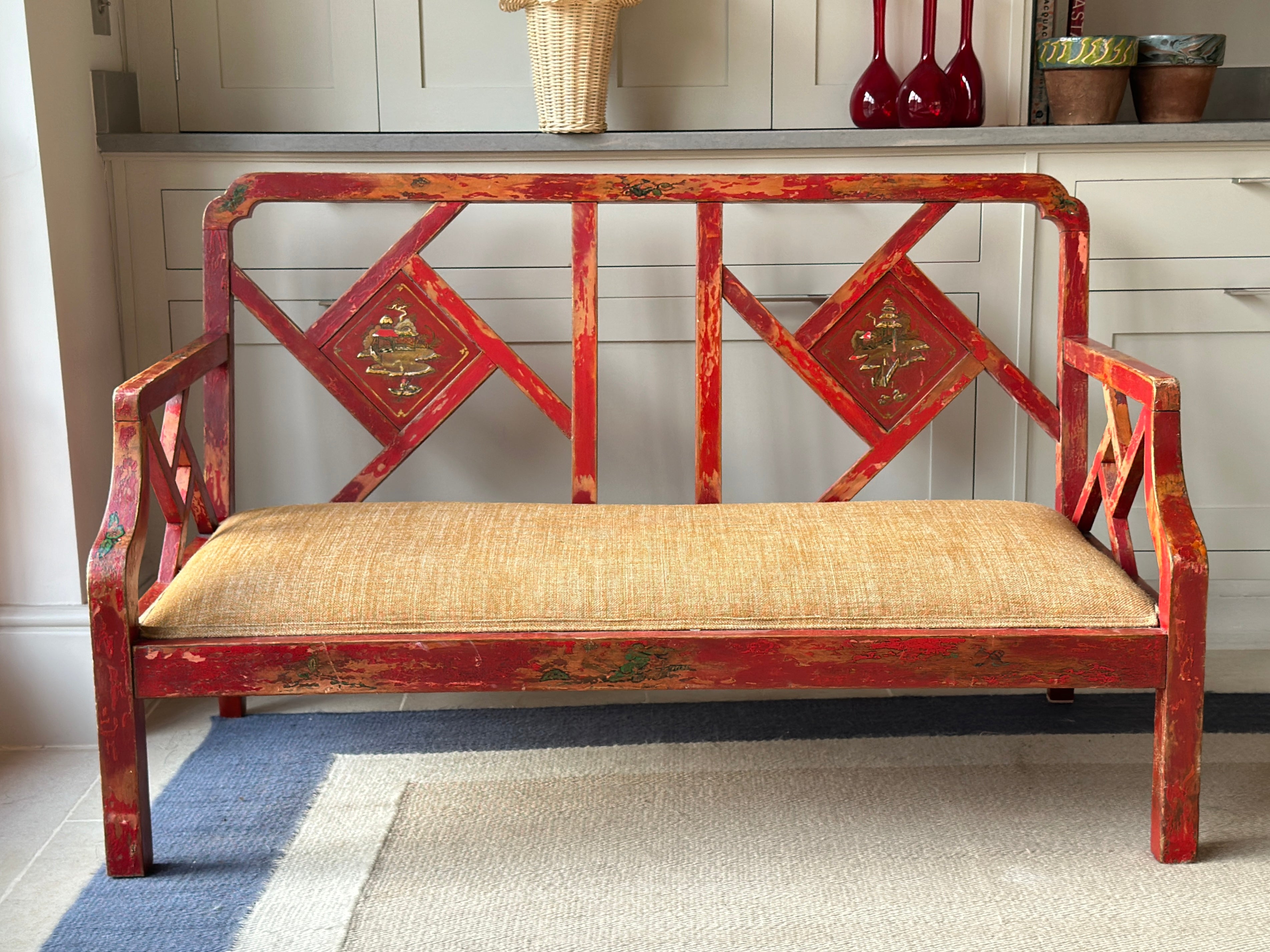 Charming Red Chinoiserie Sofa/Bench with well worn decorative paintwork.