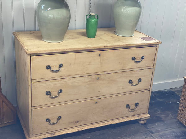 A stripped back pine chest of drawers.