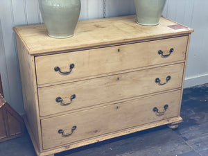 A stripped back pine chest of drawers.